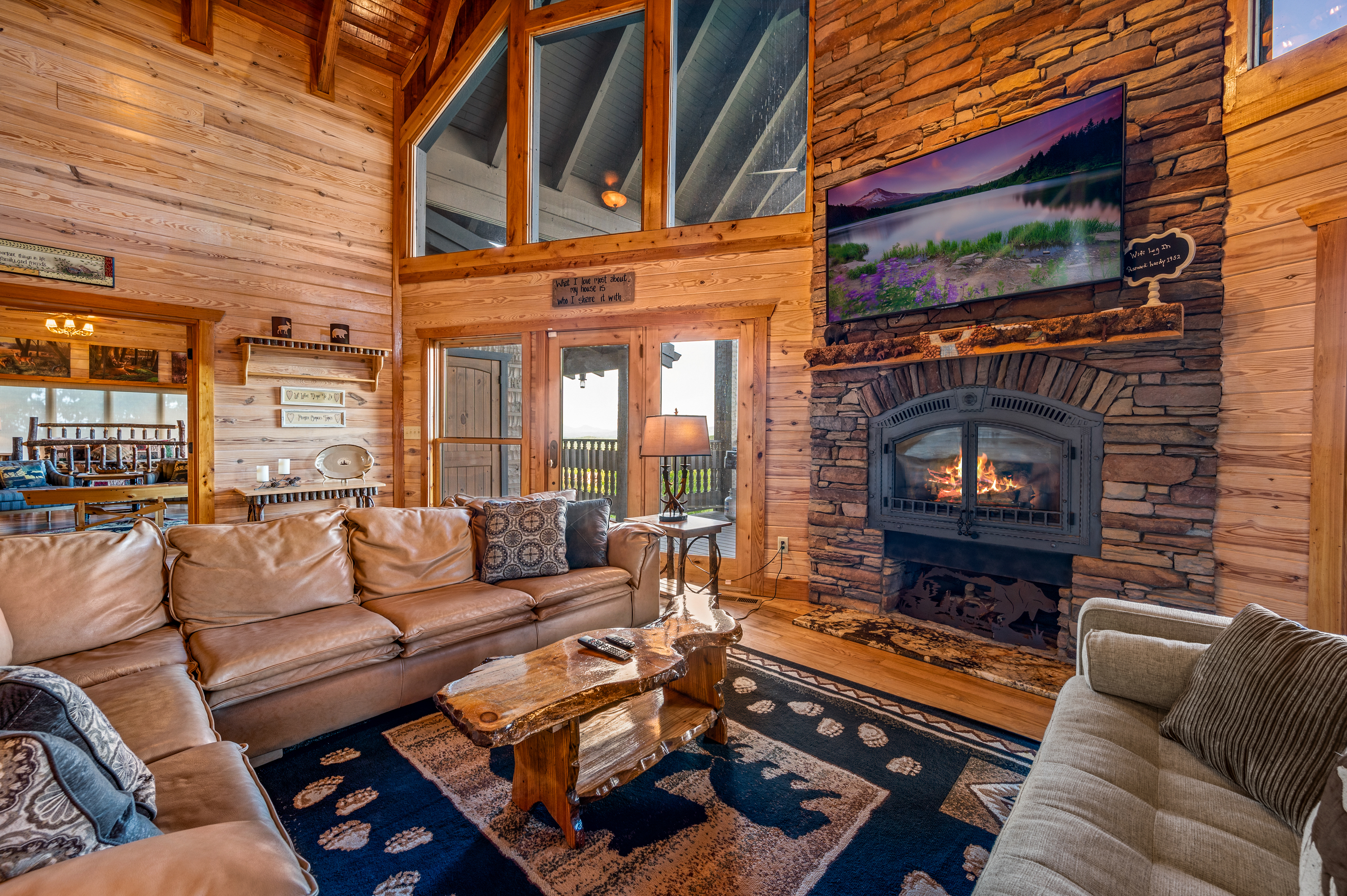 Warm timber living room with soaring ceilings and a stone fireplace